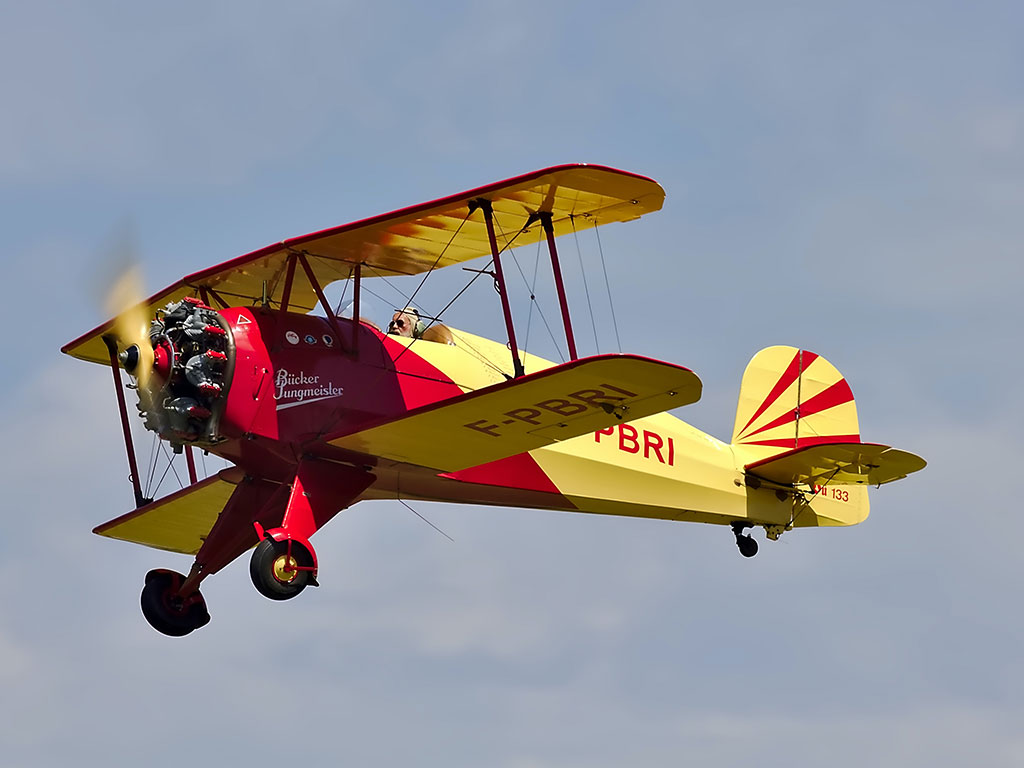 yellow and red bi-plane flying in an airshow